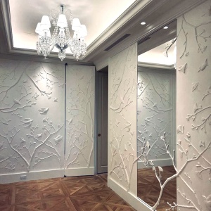 oiseaux et branches sculptés en plâtre pour le décor mural d'un appartement de luxe à manhattan, avec porte sous tenture