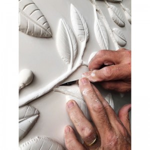 gros-plan sur le travail de finition de la sculpture gros-plan sur le travail en plâtre direct des branches de citronnier sur le panneau mural décoratif